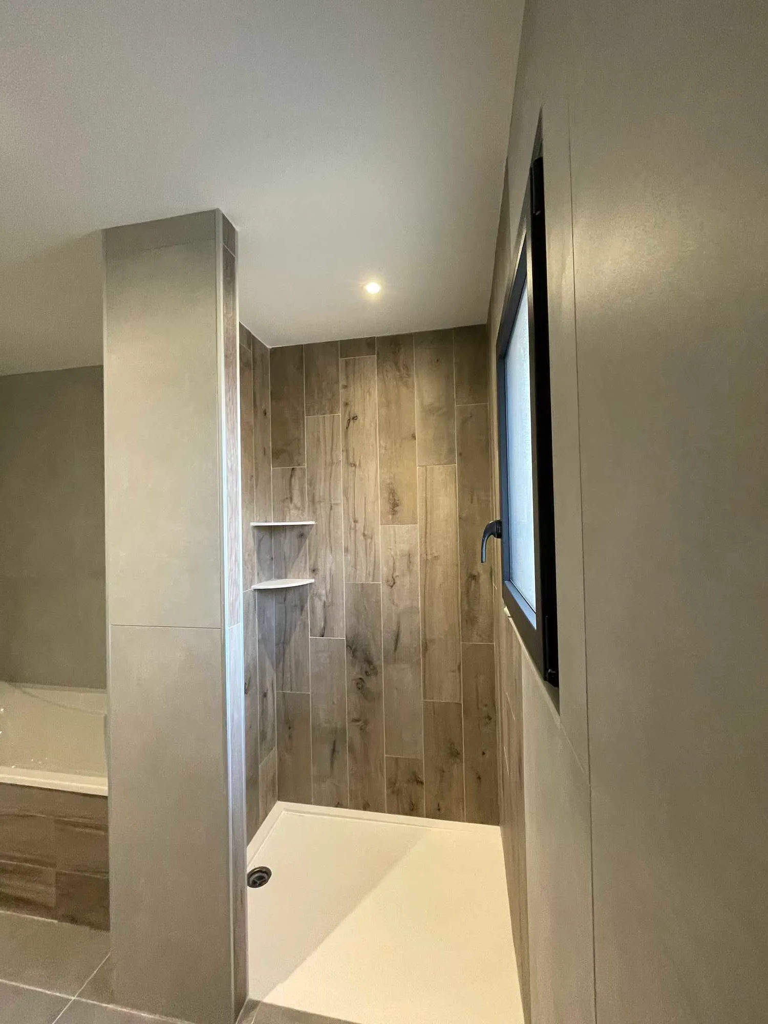 Douche à l'italienne à Toulouse habillée d'un carrelage effet bois posé en vertical avec receveur extra-plat